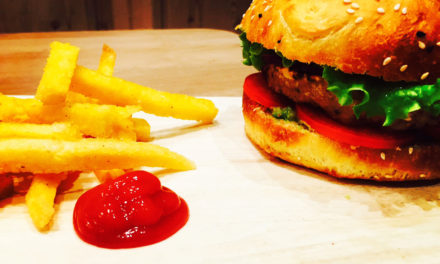 Vegan burger with cereals and lentils steak, spiced avocado sauce and fried polenta chips